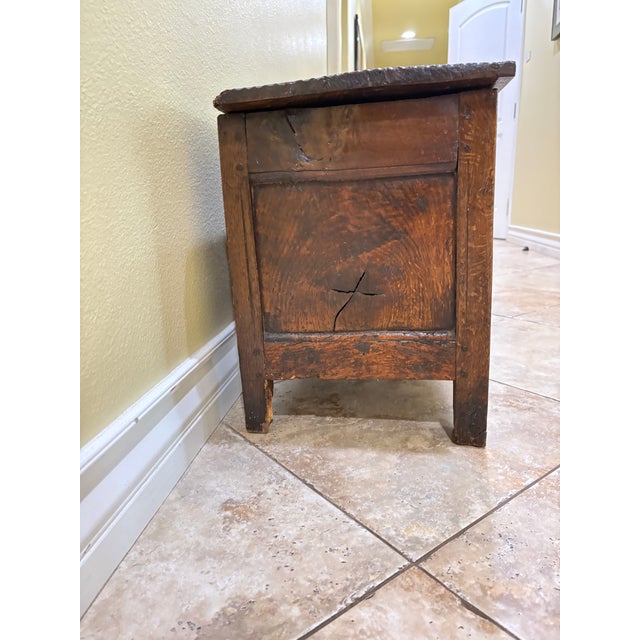 This wooden storage chest features a lift-top lid with metal strap hinges and a compartmentalized interior. The piece...