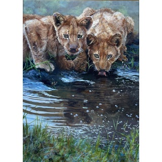 At the River by Sheri Farabaugh | Oil on canvas Two lion cubs drinking from a river. For Sale