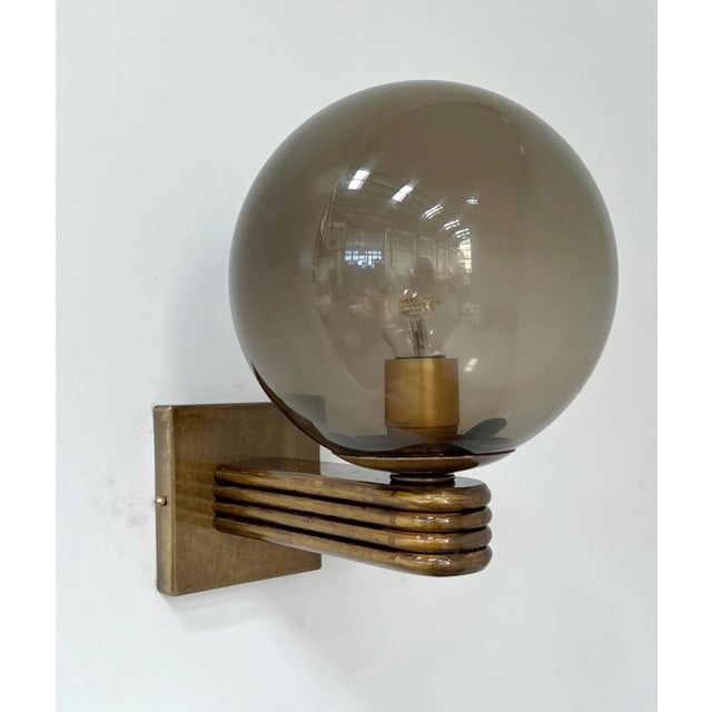 Italian Art Deco style wall light with smoky Murano glass globe mounted on Bronzed finish frame, designed by Fabio Bergomi...