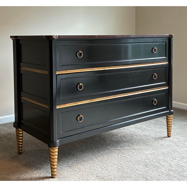 Elegant and highly sophisticated Baker three-drawer chest featuring a dramatic black lacquered finish accented with gilt...