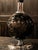 A sophisticated Italian table lamp crafted in deep black porcelain, featuring delicate floral detailing and a striking...