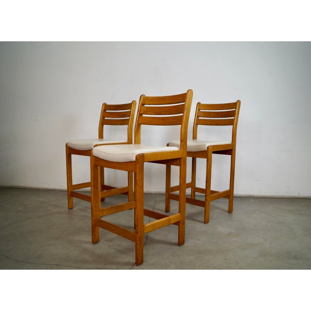 Set of three Mid century Modern counter stools for sale. These are really solid and well made, and are made of solid oak...