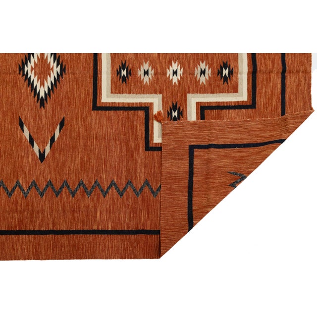 Elevate your living space with this striking Modern Navajo-style wool rug. Featuring a rich terracotta "Red Earth" ground,...