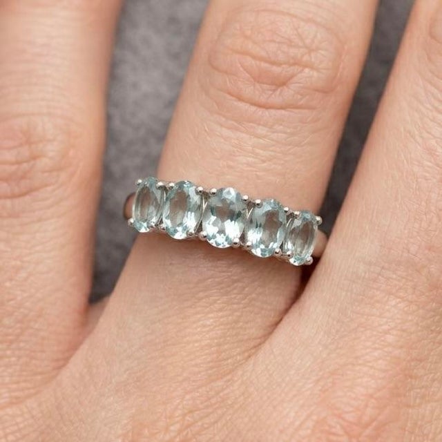 Refined and effortlessly elegant, this stunning multi-stone ring showcases a row of serene Aquamarine gemstones,...