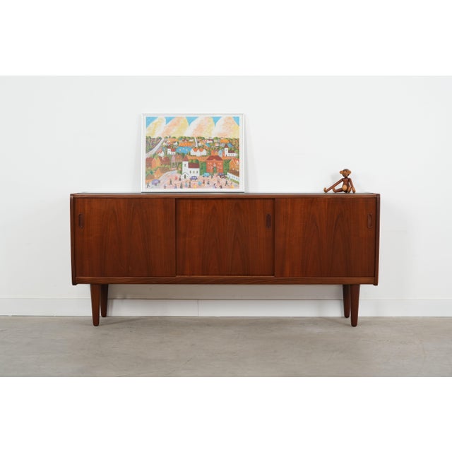 The sideboard was made in the 1970s, Danish production. The structure is covered with teak veneer. The legs are made of...