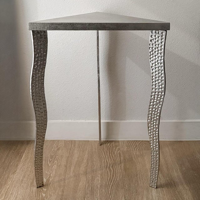 A striking sculptural side table featuring three individually worked metal legs with hammered detailing and irregular cut...