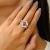 An elegant Art Deco–inspired ring featuring a deep red, square-cut garnet at its center, framed by a geometric pattern of...