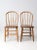 This pair of antique Windsor-style bow back chairs features elegant spindle backs, gently contoured seats, and a warm...