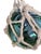 A hand-blown glass fishing float in a rich sea-green hue, hand-knotted into its original diamond-pattern jute rope netting...