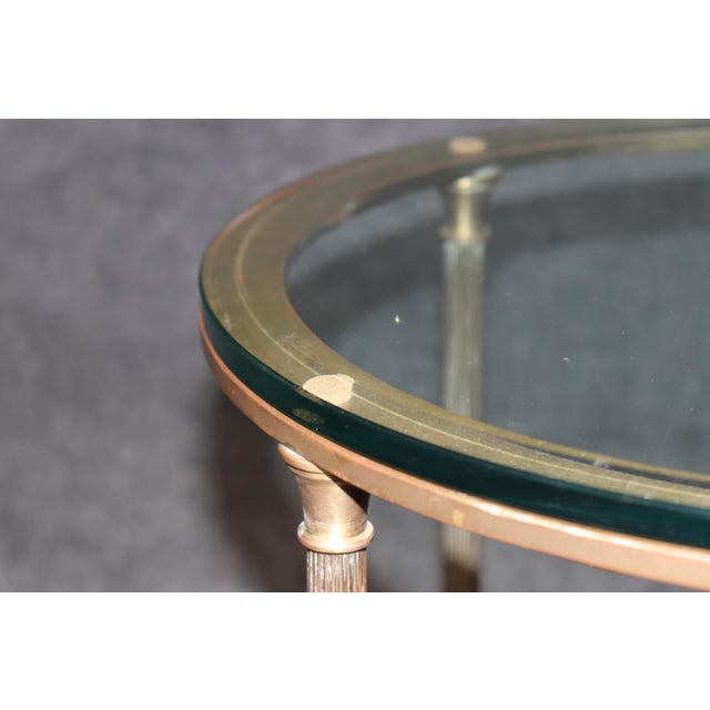 Elegant, architectural, and effortlessly sophisticated, this French Directoire style brass and glass end table is a...