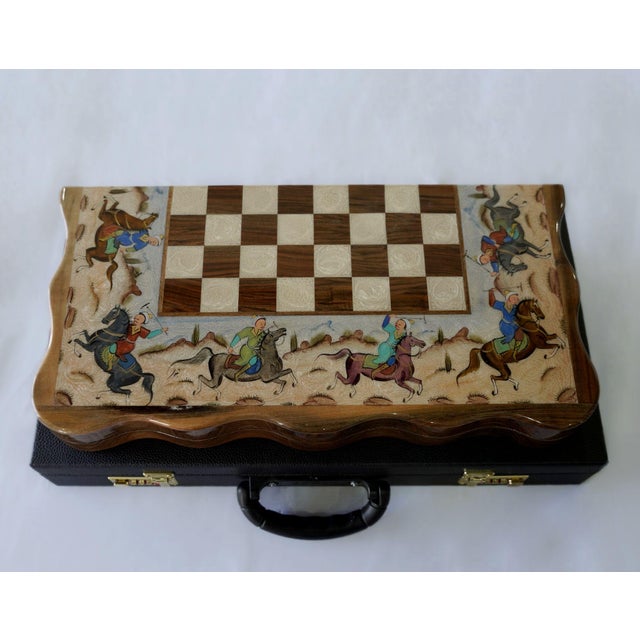 A one-of-one luxury chess and backgammon set, hand-painted with an animated polo scene surrounding the chess board. Riders...
