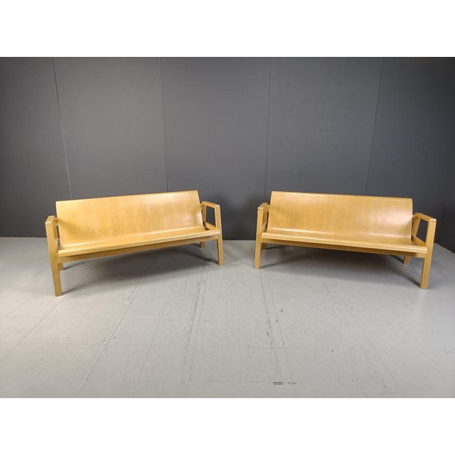 This pair of mid century benches are made out of plywood curved seats and a wooden base. The design is much like the Alvar...