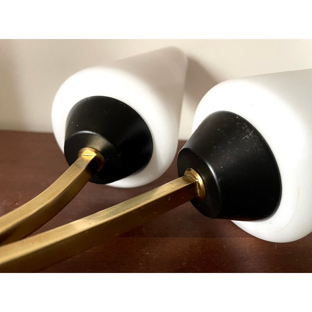 Pair of double wall sconces from the 1950s gilt brass and black metal frame large frosted white glass shades (21 cm) in...