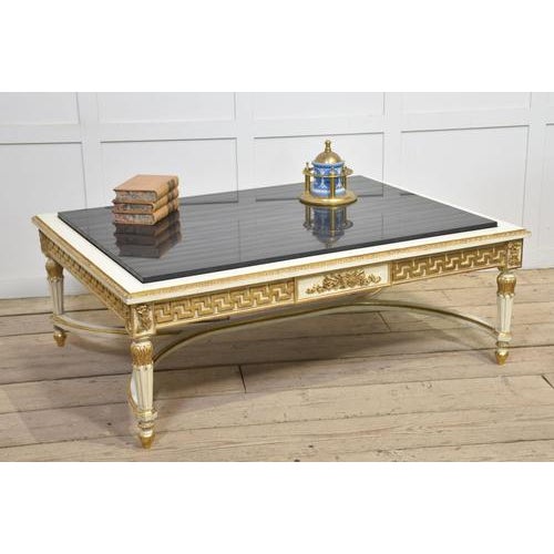 Venetian style coffee table, the large rectangular black veined marble top above cream and gilt painted base. All raised...