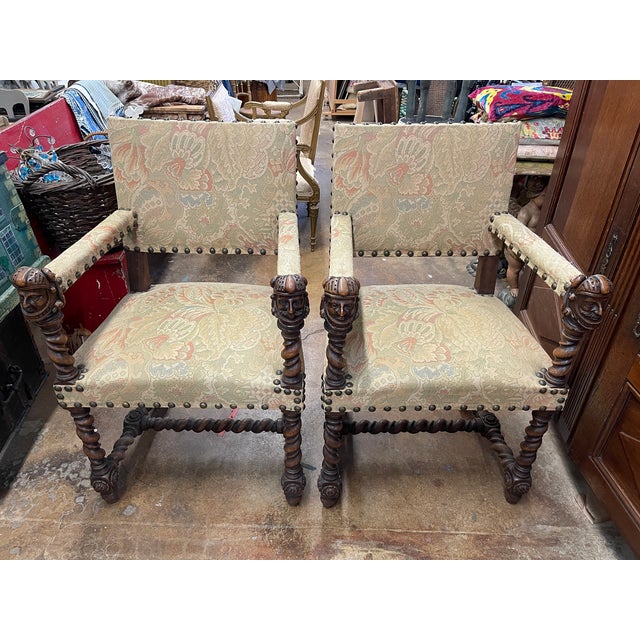 Louis XIII style open arm chairs with highly detailed carving. Character heads acting as arm rests. Barely twist...