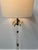 An Italian 1970s floor lamp comprising of a long acrylic glass column supported by a circular brass base with brass palm...