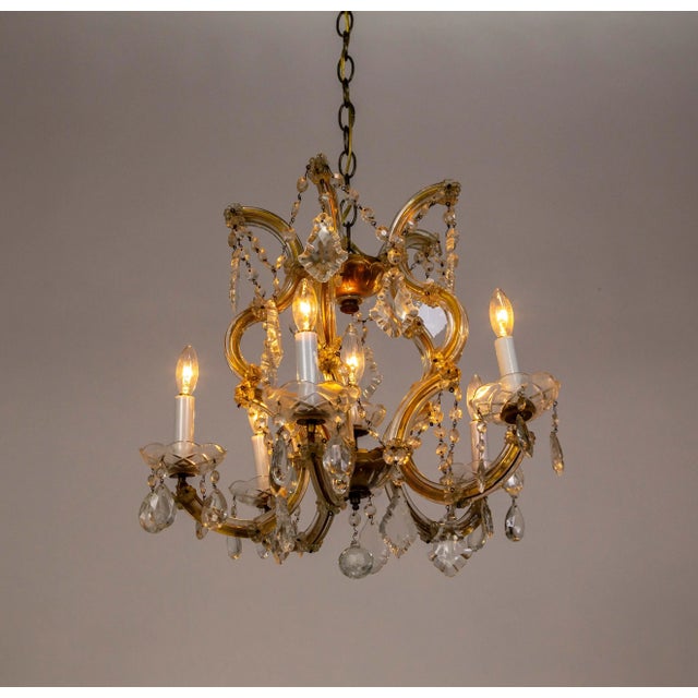 A Maria Theresa style chandelier from the 1950s. It has 5 arms with candle-style lights and a center light. With lovely...
