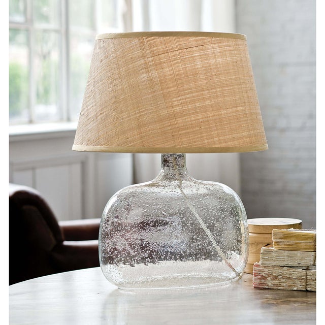 Adding a level of sophistication to any space, this table lamp is crafted of gorgeous seeded glass and topped with a...