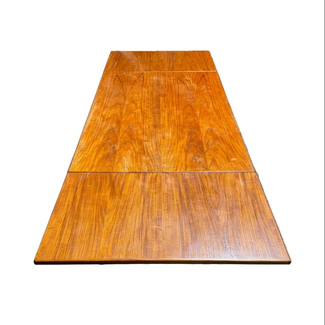 Wonderful vintage Danish draw leaf mid century modern dining table made out of teak wood. The table is constructed with a...