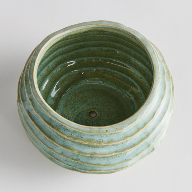 With a reactive glaze and hand finished ribbing detail, this charming sage green pot is a great find. Plant your favorite...
