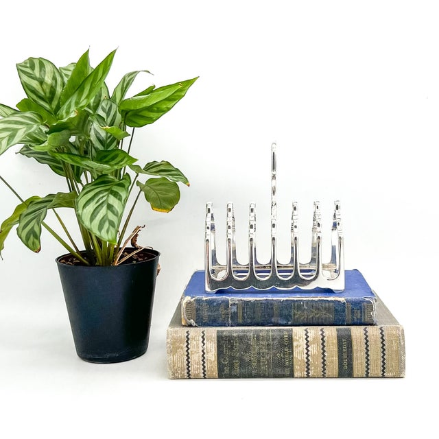 Handsome English silver-plated toast rack with seven divisions and a classic arched form. The clean, sculptural design...