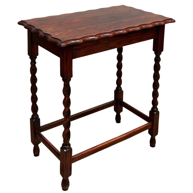 Antique English oak side table with deep red stain, pie crust top and four classic barley twist legs attached by four box...