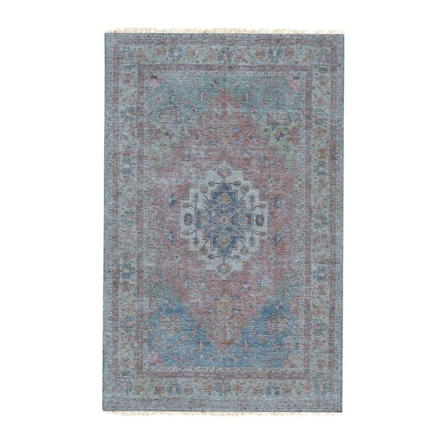 A 6' x 9' hand-knotted wool rug with a faded blue and dusty rose medallion design with a low, distressed vintage-look...