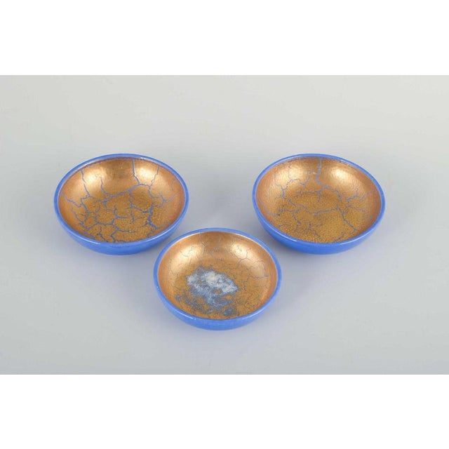 Wilhelm Kåge for Gustavsberg 3 small bowls, ca. 1930/40s. Set of three low faience bowls with blue exterior glaze and...
