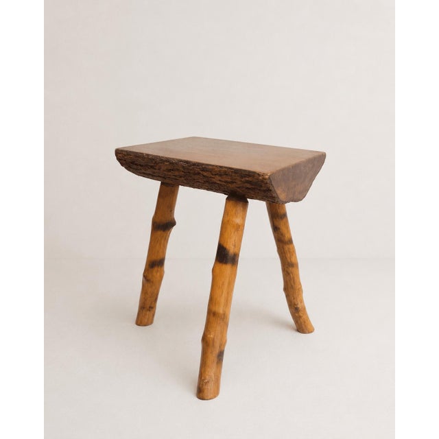 A charmingly characterful vintage rustic wooden stool that beautifully marries organic textures with classic mid-century...