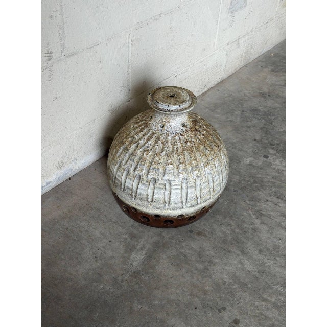 This artisanal ceramic lamp shade features a domed form with carved vertical texturing and a ring of circular lower...