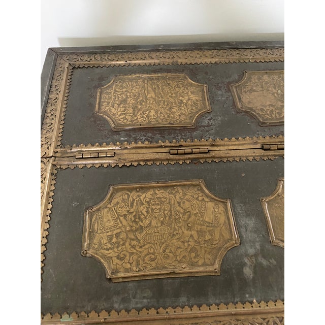 Unusual intricately engraved chest from India. The heavy teak base is wrapped in tin with inset shaped panels of brass...