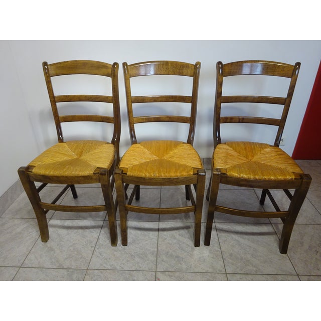Set of 3 Baumann chairs, 1980s/90s model. High-gloss varnished beechwood frame, removable straw seat. Curved legs at the...