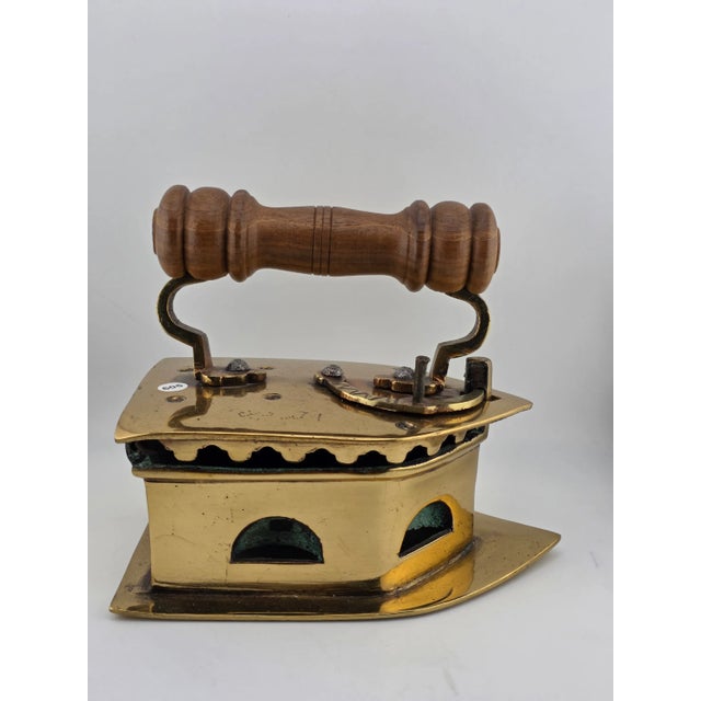 The product is an antique C1850 Middle East handmade brass charcoal big press iron with a wooden handle. This press iron...