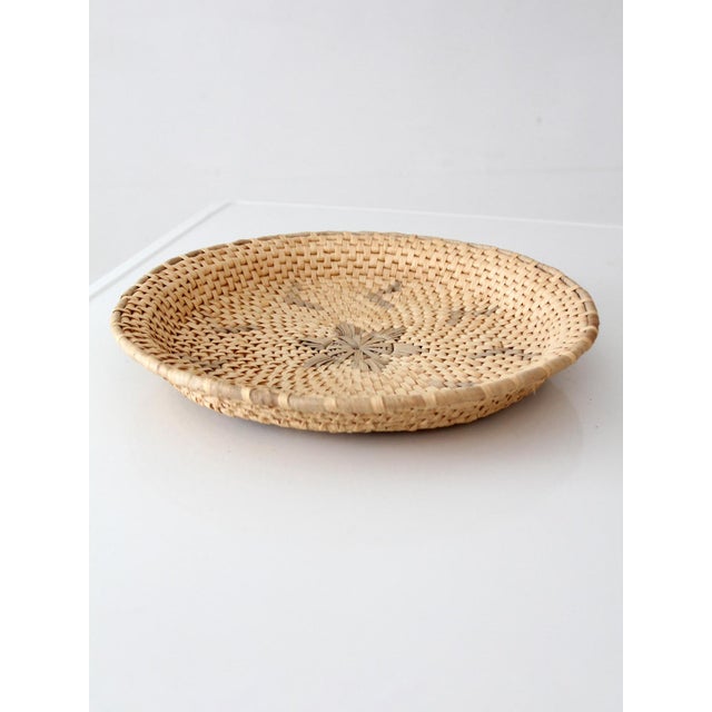This handwoven Southwestern style basket tray features a tightly woven natural fiber construction with a subtle gray...