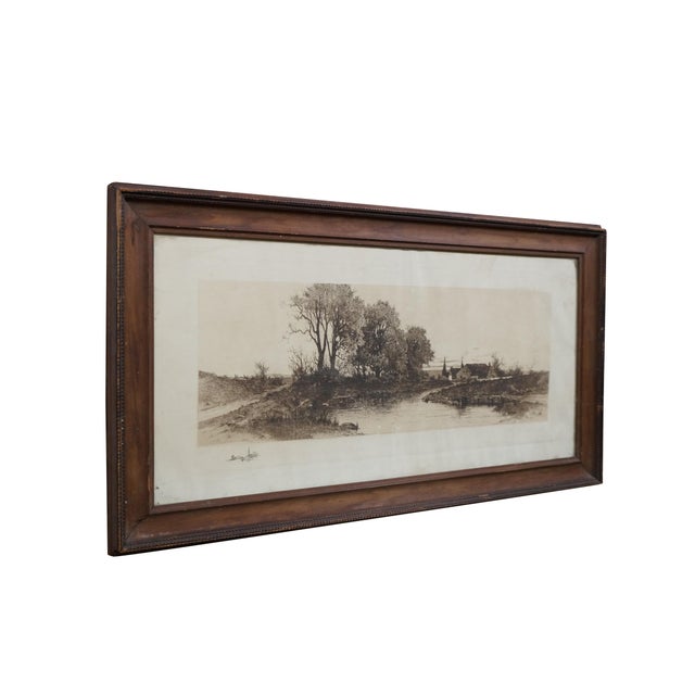 Antique panoramic rural riverscape featuring a cluster of leafy trees, small cottages or farmhouses along the water, a...
