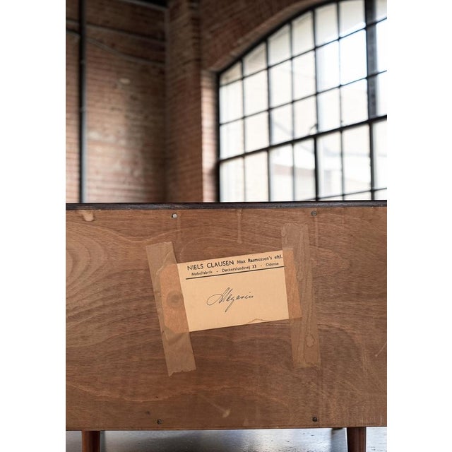 Chest of drawers executed in rosewood with three drawers raised on slender legs. Produced by niels clausen møbelfabrik in...