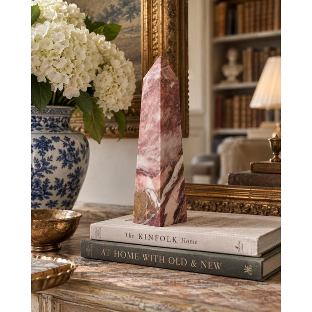A beautifully proportioned marble obelisk in richly veined shades of red, purple, and brown. The sculptural silhouette and...