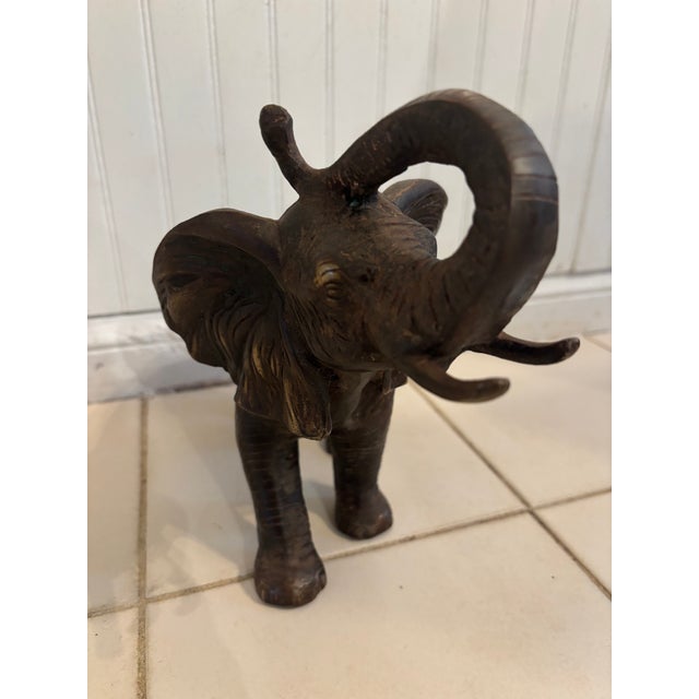 A beautifully articulated cast bronze African Elephant figure, late 29th, early 20th century, trunk raised, ears flapping,...