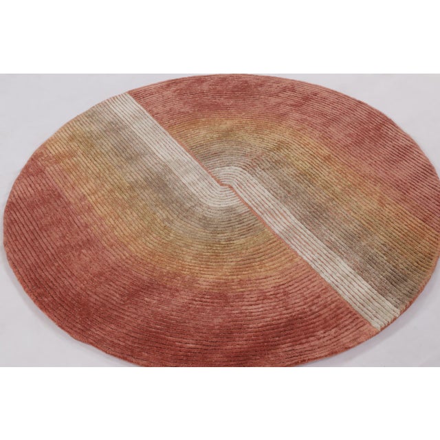 This modern round rug from India showcases a striking balance between texture, form, and tonal warmth. Measuring 5 x 5,...