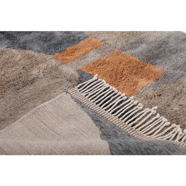 Muted tones, bold form — a study in modern restraint. This hand-knotted Moroccan rug pairs an earthy, textured field of...