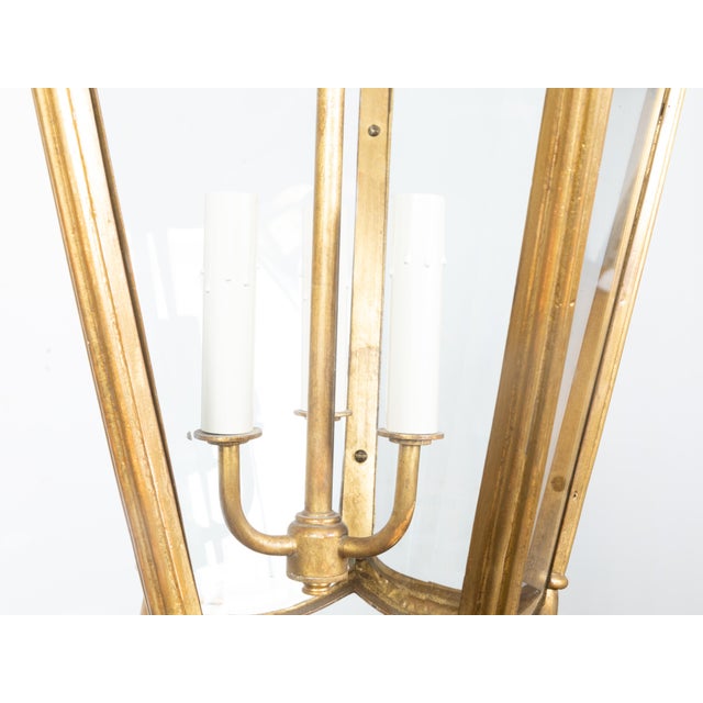 A Midcentury Continental Art Nouveau style gilt metal lantern with three lights. Immerse your space in the classic...