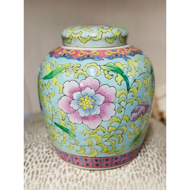 This is a decorative lidded porcelain ginger jar or tea caddy in a Chinese-inspired style. It has a soft celadon-blue...
