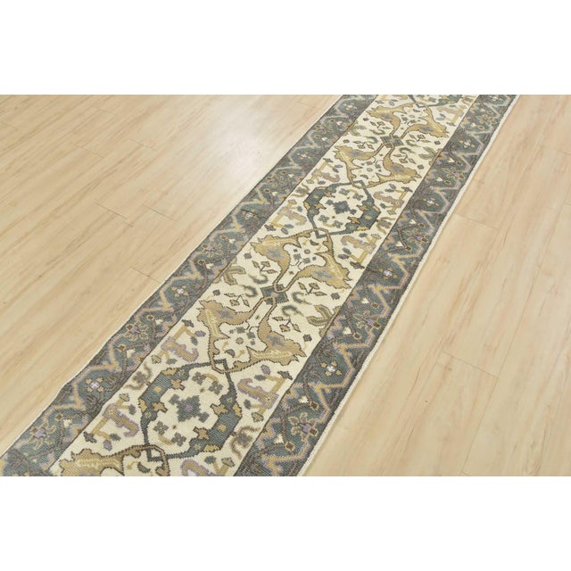 This traditional tribal Oushak runner is hand-knotted with an all-wool pile on a cotton foundation. This rug is new and in...