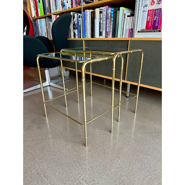This vintage mid-century modern set of two nesting tables, designed circa 1970, features structural elements reminiscent...