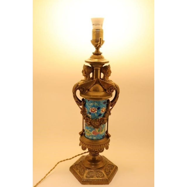 A captivating piece of late 19th-century French decorative art.This exquisite table lamp features a vibrant ceramic body...
