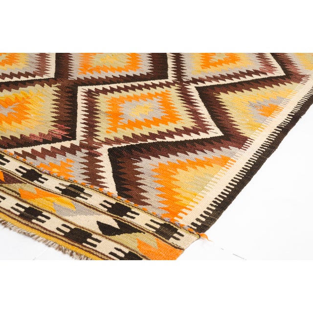 This is a vintage Turkish Oushak rug from the Mid 20th Century. The piece was hand-knotted.