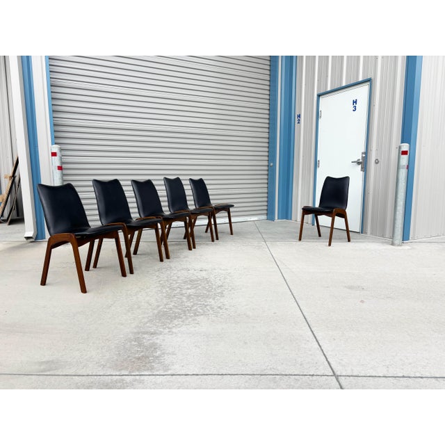 Mid-century walnut and black vinyl dining chairs, set of six, designed by Chet Beardsley and manufactured in the United...