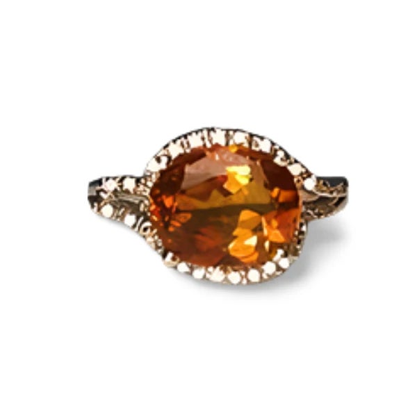 This fabulous estate ring is crafted in luxurious 18K white gold and features a vibrant oval orange citrine surrounded by...