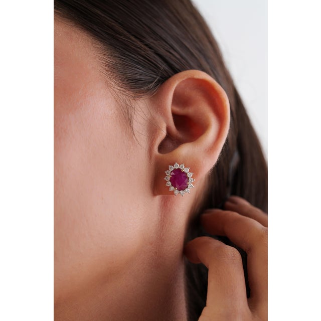 These striking halo cluster stud earrings feature 4.86 carats of ruby and diamond, set in 18k yellow gold. Each ruby...