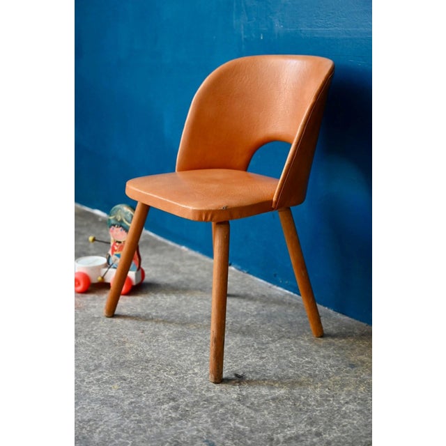 This small barrel chair for children is a charming retro piece from the 1960s. with its splayed legs and enveloping camel-...